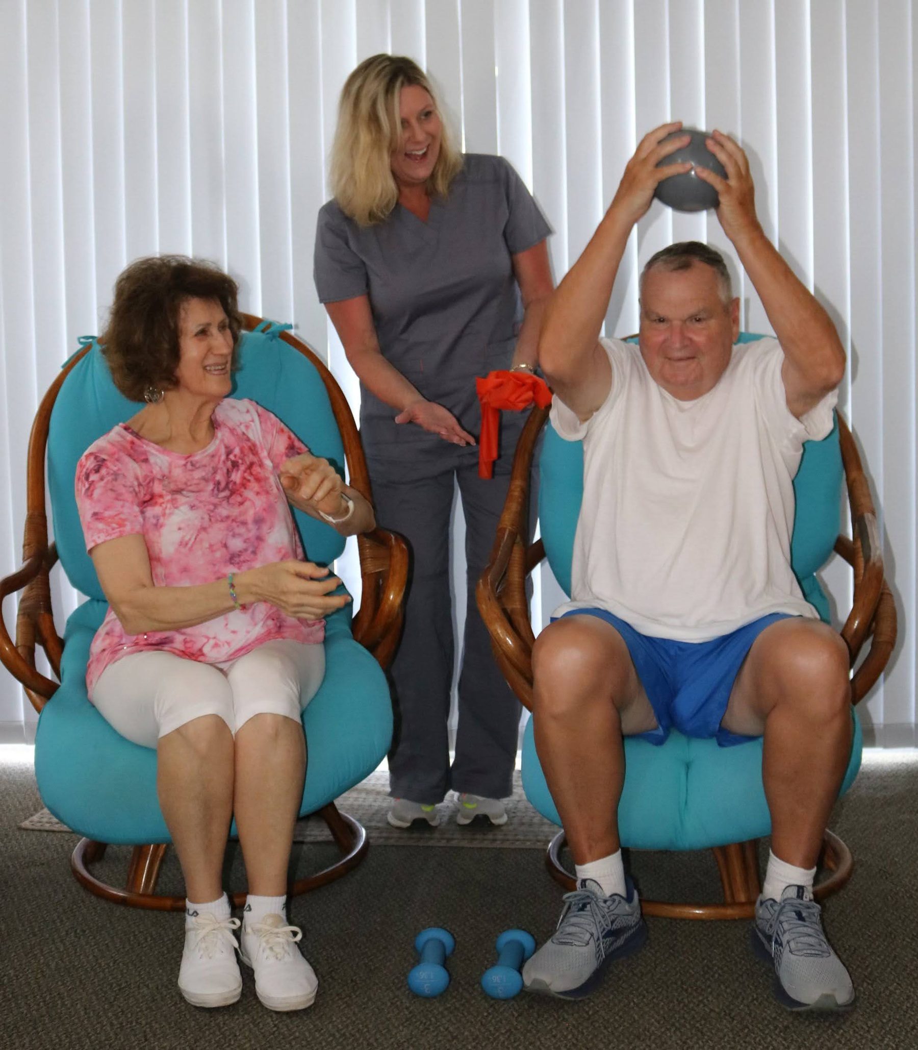 Two residents passing a medicine ball together with a therapist assisting